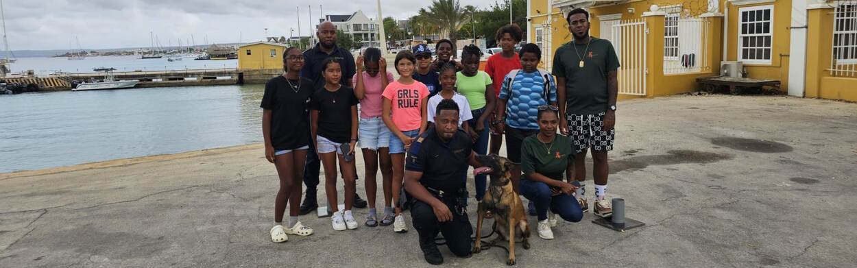 Leerlingen van Jeugdhuis Jong Bonaire staan samen met Douane ambtenaren op de foto ivm bedrijfsbezoek